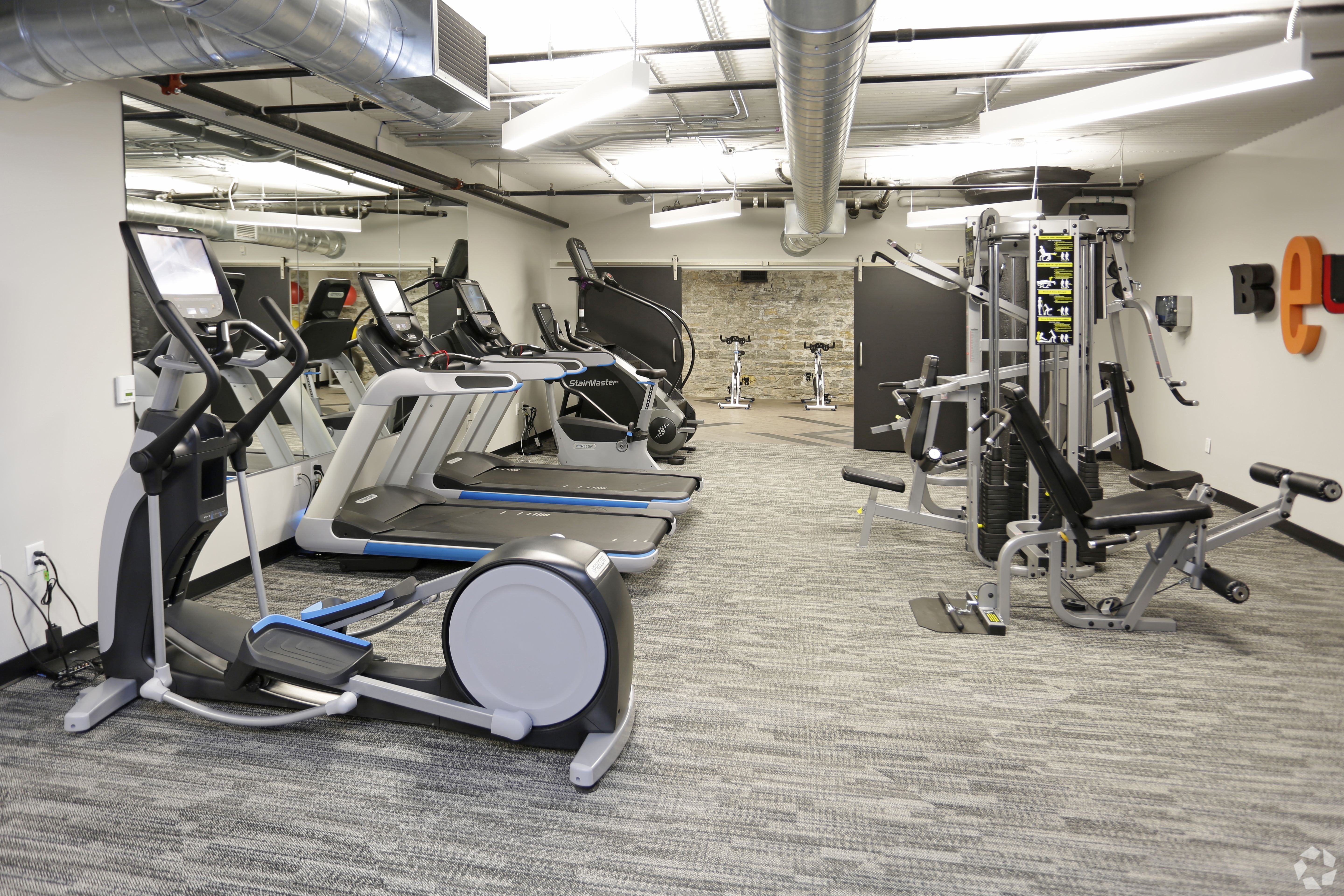 A gym with treadmills, elliptical machines, and other exercise equipment.